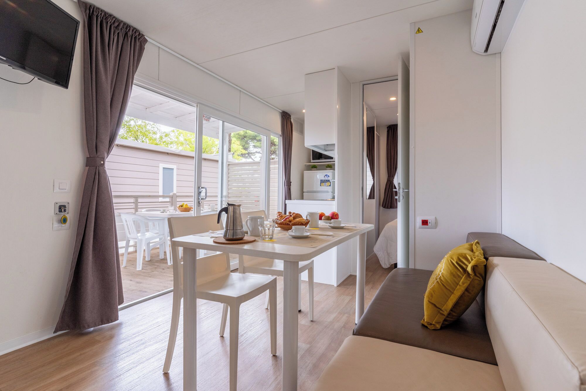 Ein modernes Interieur mit Essbereich, einer Couch und einer Küchenzeile.