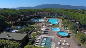 Un complexe hôtelier doté de plusieurs piscines, de chaises longues et offrant une vue sur un paysage montagneux.