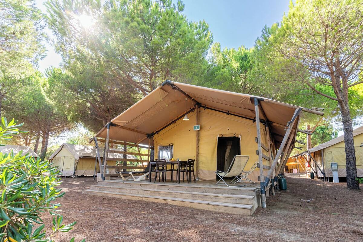 Un terrain de camping équipé d’une seule tente, d’une table et de chaises.