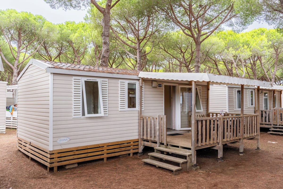 Une rangée de maisons mobiles dotées de terrasses en bois et d’escaliers menant à l’entrée.