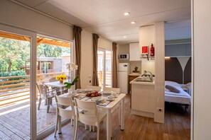 A compact hotel room with a balcony, a kitchenette, and a bed. - Club del Sole Stella del Mare Family Collection. (Castiglione della Pescaia)