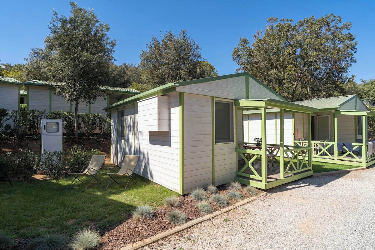 A small, single-story building with a green roof and a covered porch area.