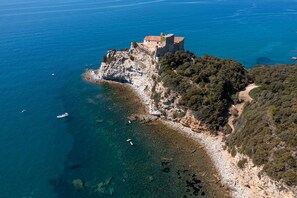 A coastal castle with a clear view of the surrounding sea and rocky terrain. - Club del Sole Stella del Mare Family Collection. (Castiglione della Pescaia)