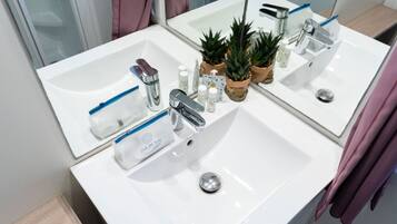 A bathroom with two sinks, a mirror, and various toiletries.