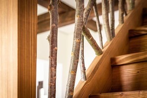 A wooden staircase with a rustic design, featuring exposed wooden beams and a natural finish. - Pension Kleiner König (Struppen)