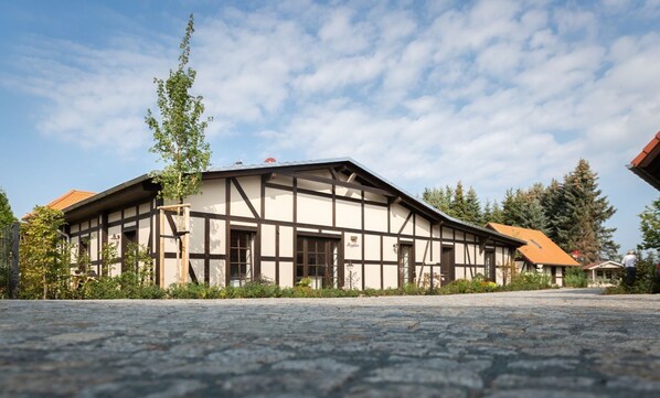A traditional half-timbered building with a stone-paved courtyard.