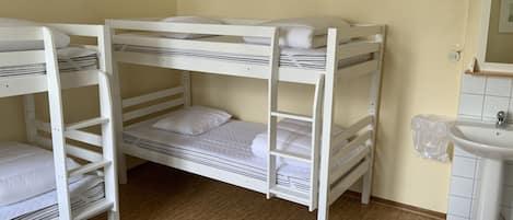 A bunk bed room with a sink and mirror.