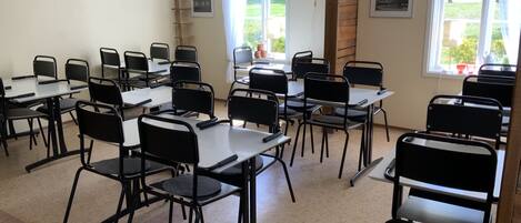 A classroom with tables and chairs arranged for a meeting or class.