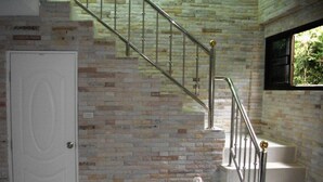 Eine Treppe mit Metallgeländer und einer Backsteinwand.