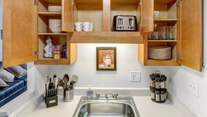 A kitchen with wooden cabinets, a toaster, and a sink.