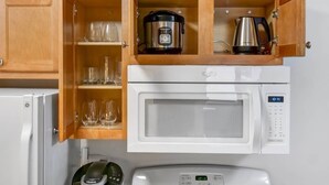 A compact kitchen with a microwave, a coffee maker, and a kettle.