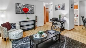 Un salon moderne avec un canapé, une table basse et des œuvres d’art accrochées aux murs.