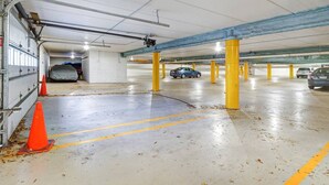 Eine Tiefgarage mit gelben Säulen, Betonböden und orangenen Verkehrskegeln.