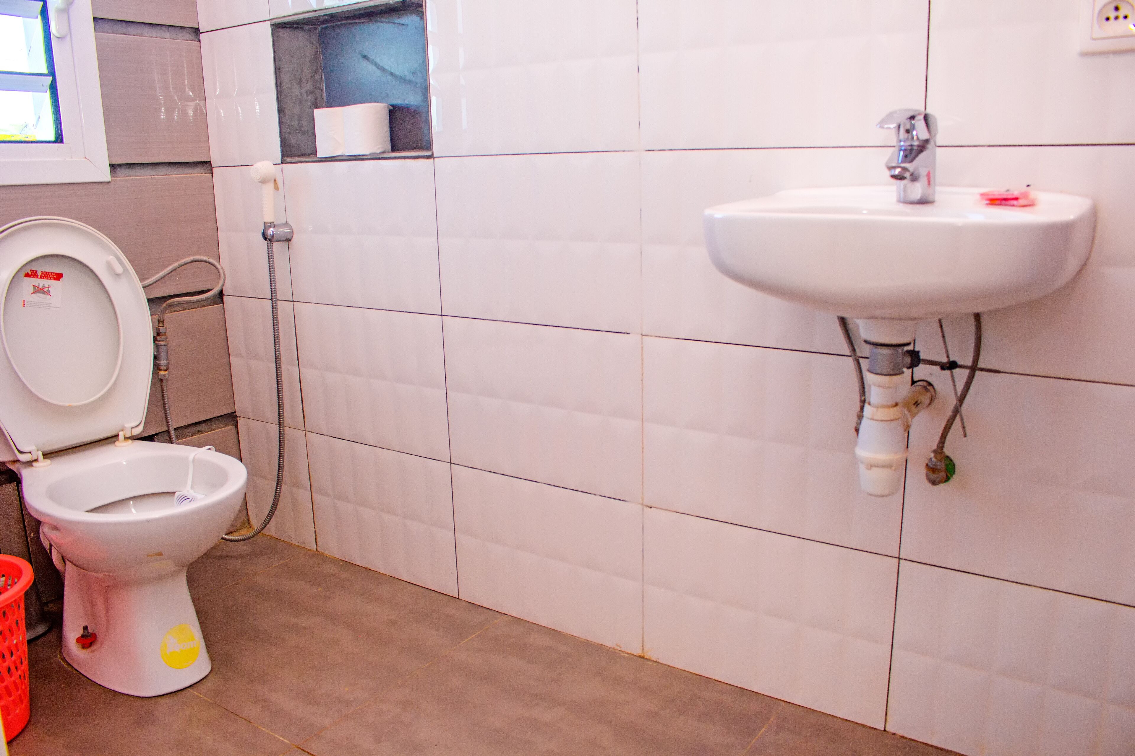 A bathroom with a toilet, a sink, and a hand dryer.