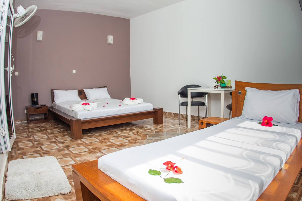 A hotel room with two beds, a desk, and a chair.