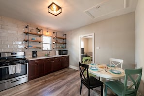 Enjoy cooking in the well-equipped kitchen with a stainless steel stove, microwave, and wooden cabinets.
