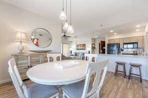Una cocina moderna con armarios blancos, una isla central e iluminación colgante.