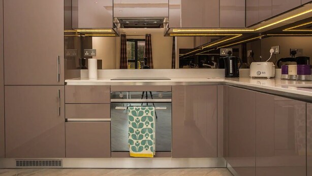 Una cocina moderna con electrodomésticos integrados, lavavajillas y cafetera.