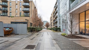 En bostadsbyggnad med ett gym på bottenvåningen, belagda gångvägar och modern arkitektur.