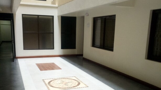 A corridor with tiled flooring, large windows, and a central decorative tile. - Skyline Hotel & Suites (Nakuru)
