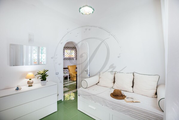 A bedroom with a bed, a dresser, a mirror, and a green floor.