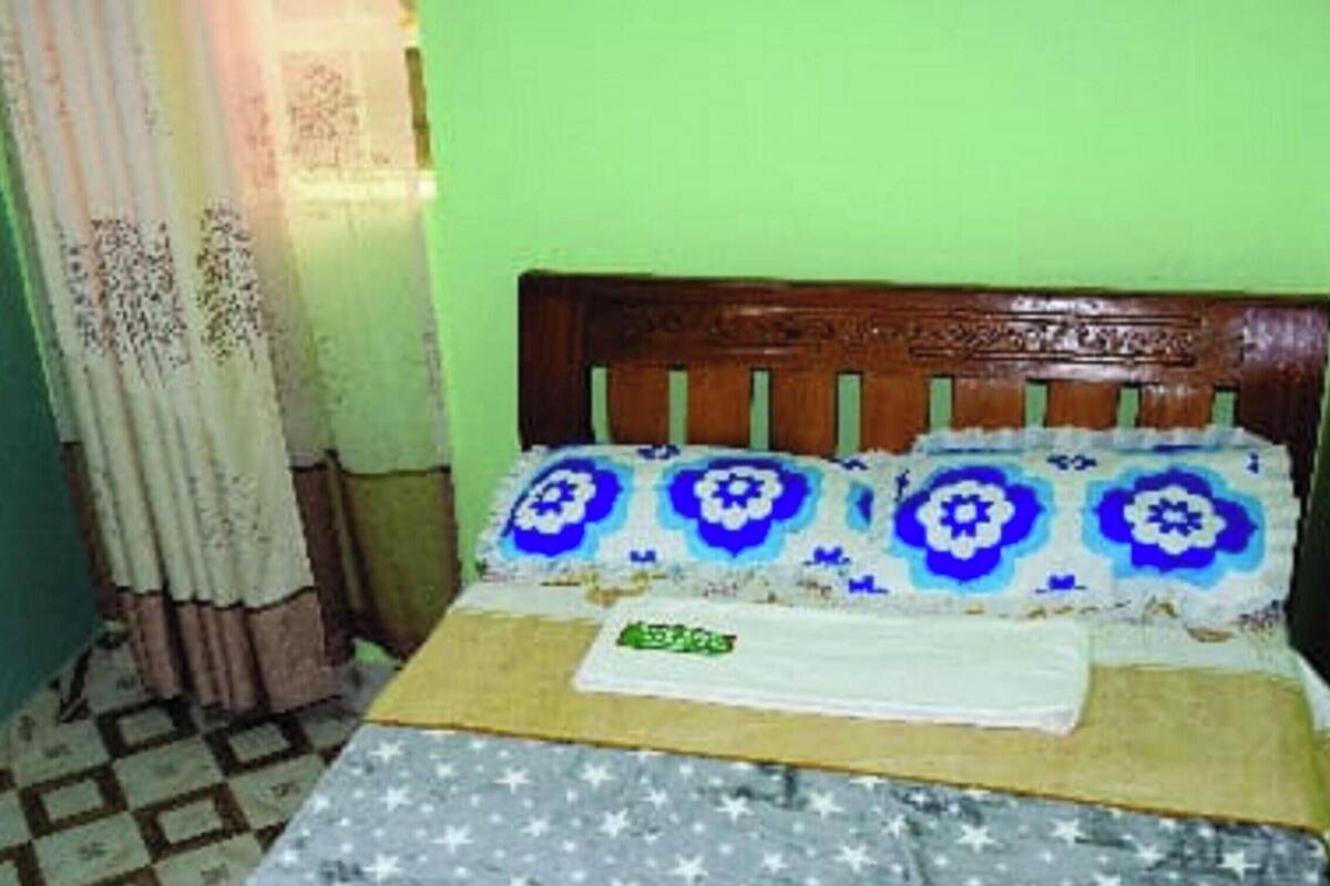 A room with a bed, a curtain, and a patterned floor.