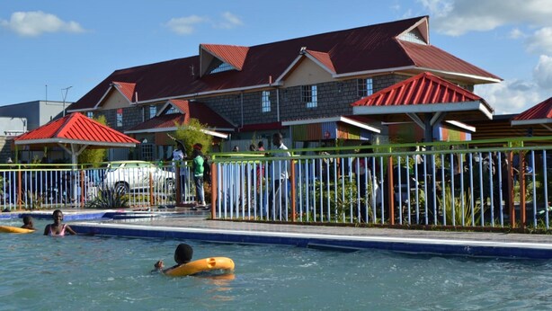 Un área de piscina con un edificio al fondo.