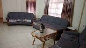 A living room with two sofas, a coffee table, and a small side table. - AJ's The Ranch (Nanyuki)