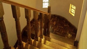 A wooden staircase with a herringbone floor pattern leading to a landing. - AJ's The Ranch (Nanyuki)