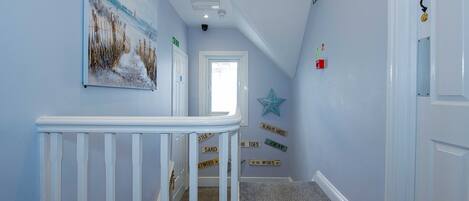 A hallway with a white railing, a star decoration, and motivational signs on the wall.