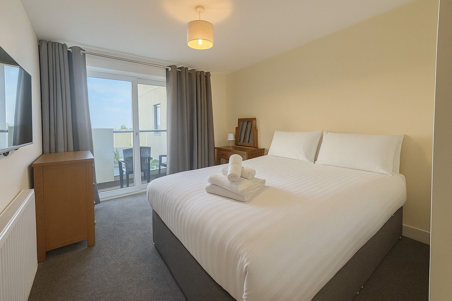 Een laptopwerkplek, een strijkplank/strijkijzer, beddengoed