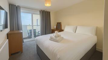 Een laptopwerkplek, een strijkplank/strijkijzer, beddengoed