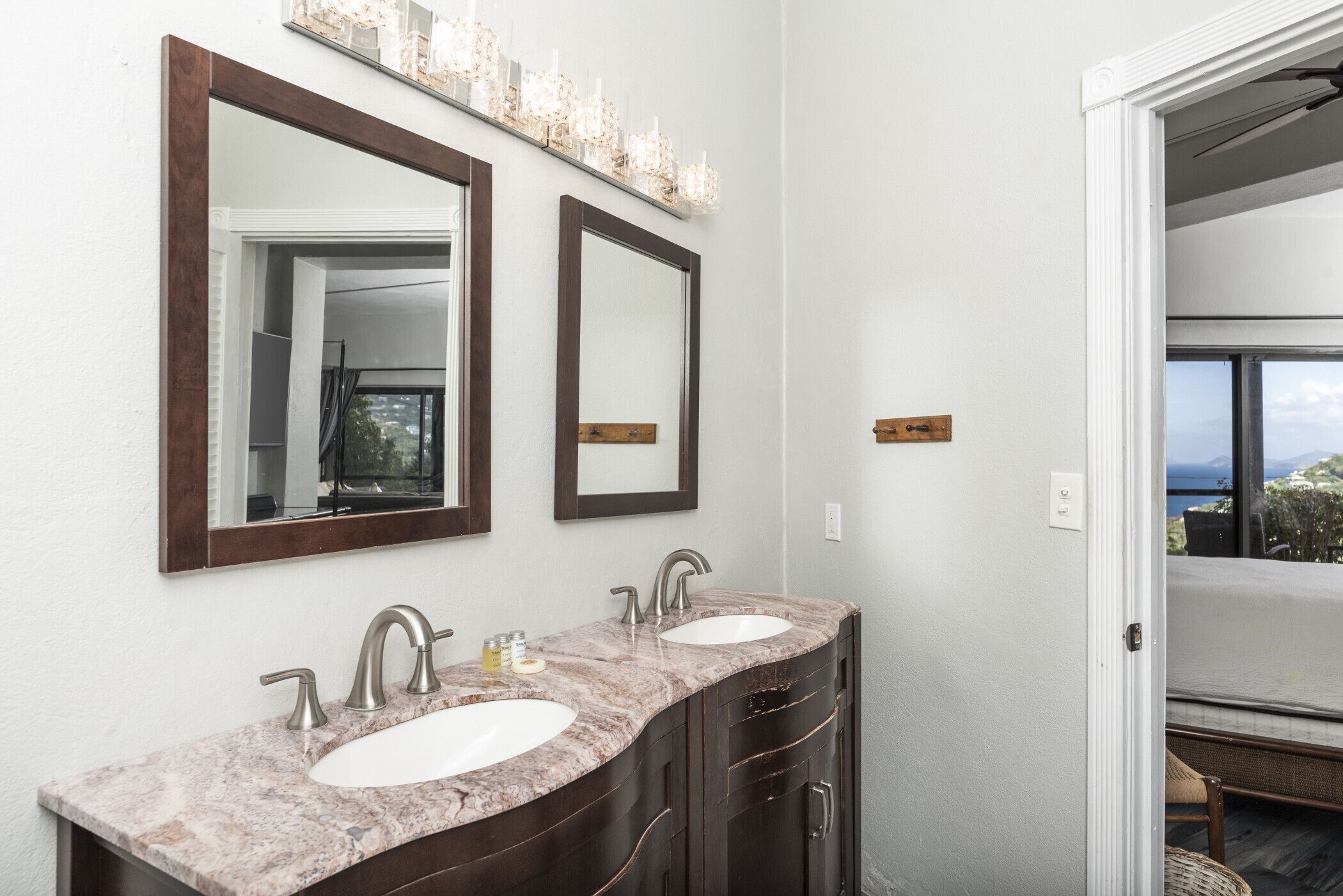 Une salle de bain avec deux lavabos, des meubles en bois foncé et un grand miroir au-dessus des lavabos.