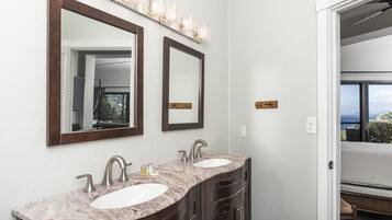 Une salle de bain avec deux lavabos, des meubles en bois foncé et un grand miroir au-dessus des lavabos.