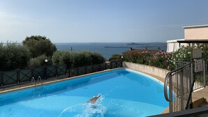 Une piscine avec vue sur la mer et sur la côte lointaine.