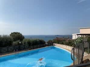 Una piscina con vistas al mar y a la costa lejana.