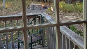 A wooden deck with a fire pit and a chair. - Rustic Retreat Cabin for Families/Sm Groups, "Shalom" (South Range)