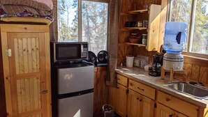 A compact kitchen with a refrigerator, microwave, and a water dispenser. - Rustic Retreat Cabin for Families/Sm Groups, "Shalom" (South Range)