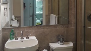 Une salle de bain équipée d’un lavabo, de toilettes et d’une douche à parois en verre.