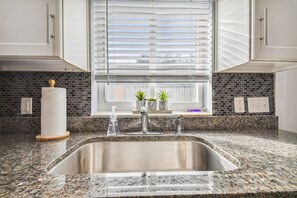 Enjoy cooking in this well-equipped kitchen with a stainless steel sink, granite countertops, and ample cabinetry.