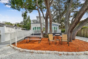 Relax in a serene outdoor space surrounded by mature trees and comfortable seating.