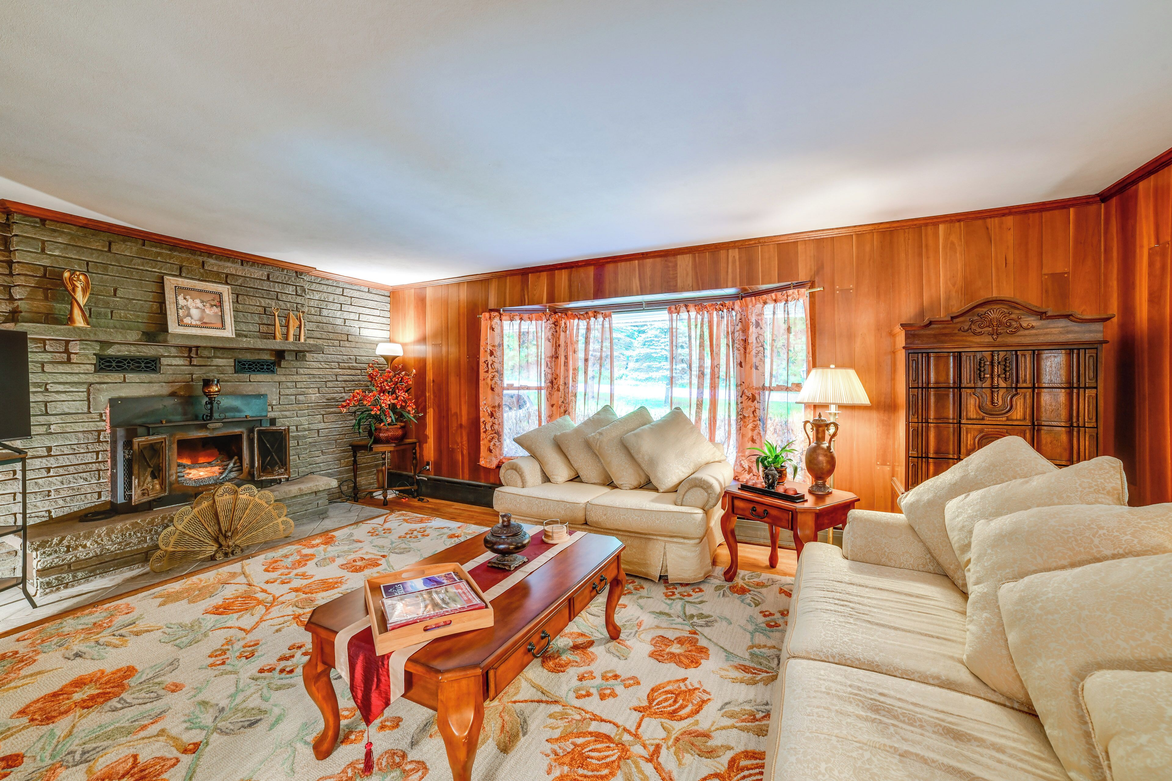 A cozy living room with a fireplace, a sofa, a coffee table, and a wooden cabinet.