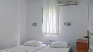 A room with two beds, a small wooden desk, an air conditioning unit, and a marble-patterned floor. - Miramonte Apart Hotel (Marmaris)