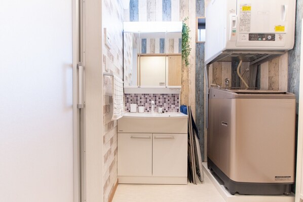 A compact kitchen with a built-in dishwasher, a small countertop, and a tiled backsplash.