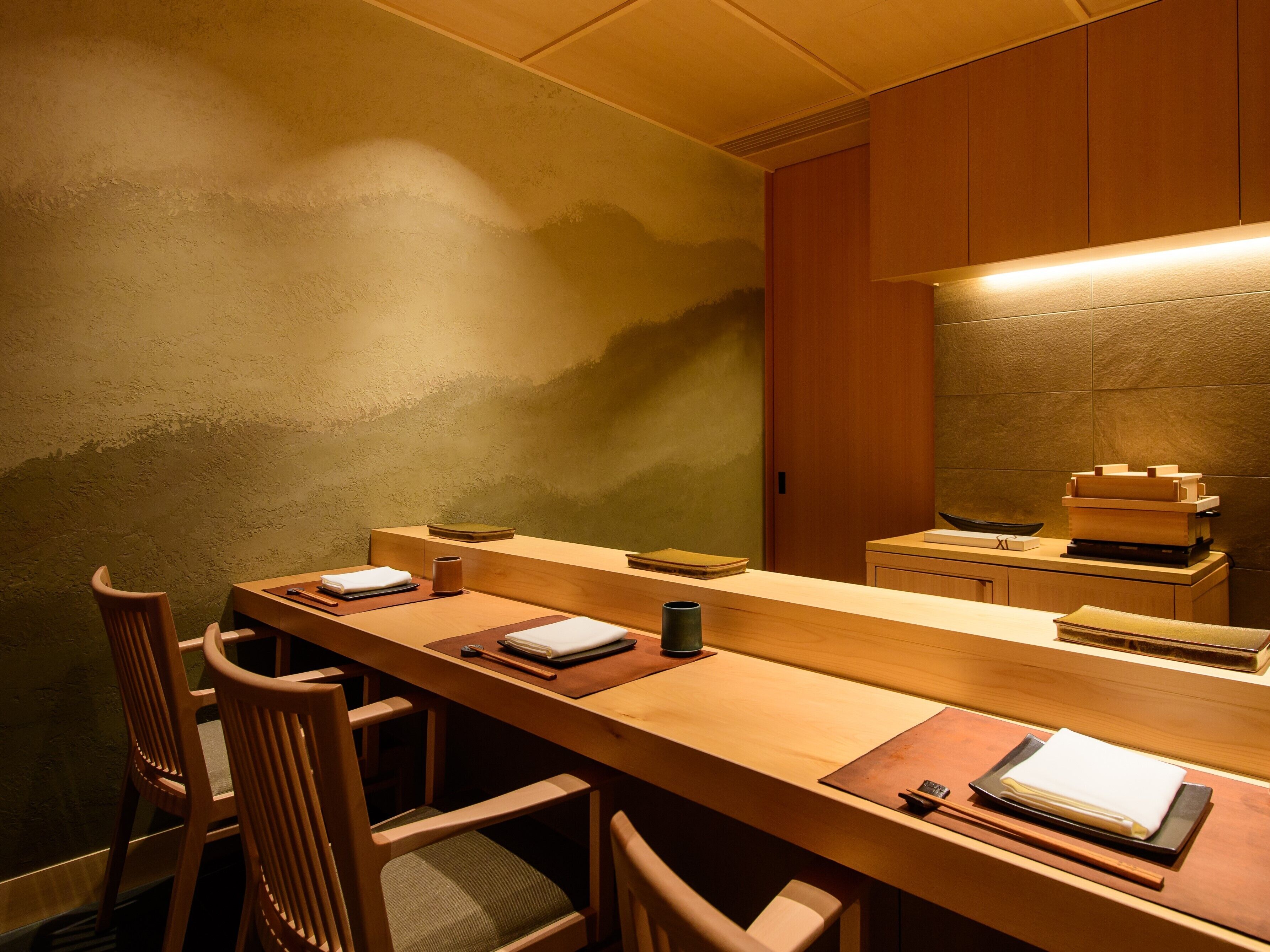 A wooden reception desk with a counter, chairs, and a wall-mounted telephone.