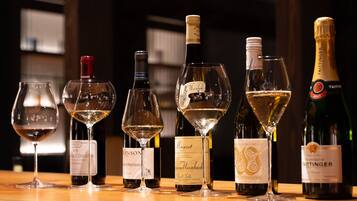 A selection of wine bottles and glasses on a wooden table.