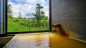 Relax in a serene hot tub surrounded by a lush green landscape and tranquil views.