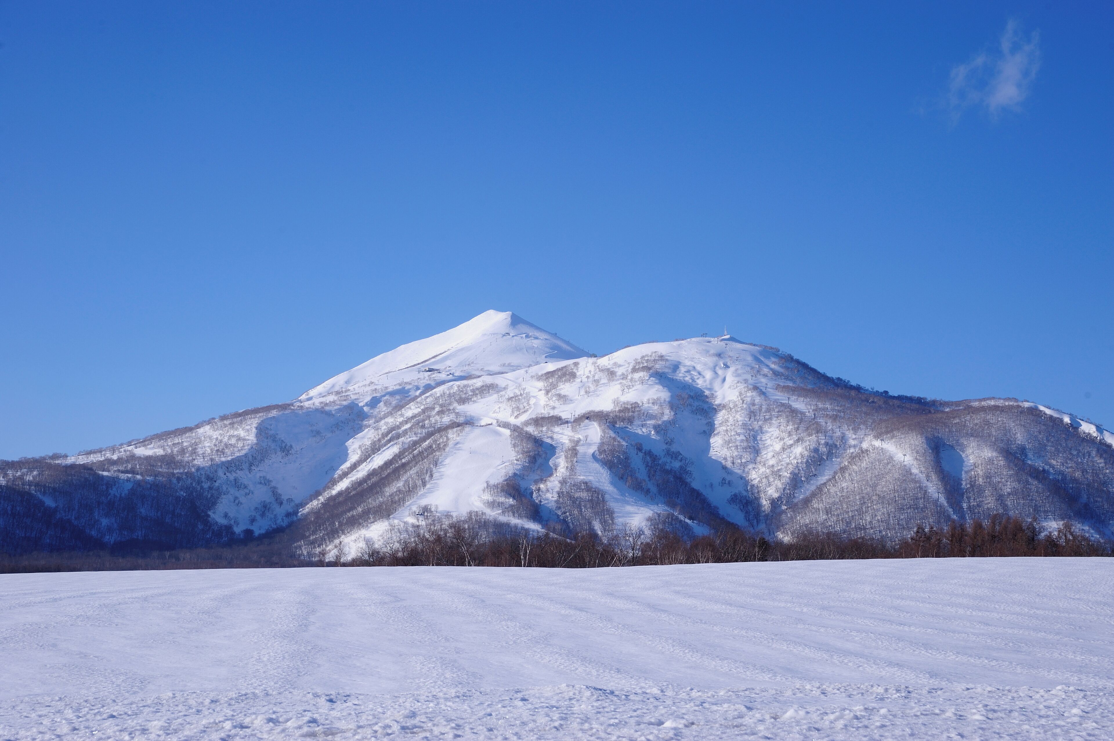 A snow-covered mountain with a clear blue sky.