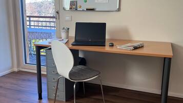 A workspace with a laptop, chair, and whiteboard.