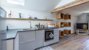 Een moderne keuken met een ingebouwde oven, een spoelbak en houten planken erboven.